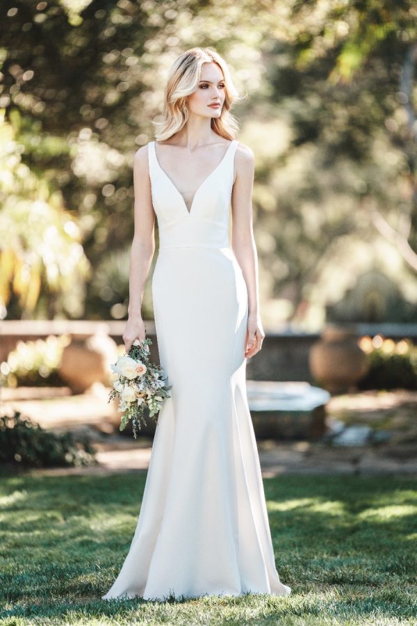 The stunning, clean lines of this fitted crepe sheath gown are emphasized by a deep neckline and back.