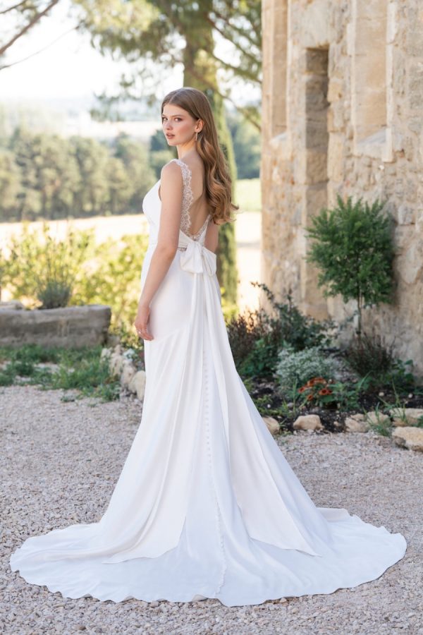 Graced with Chantilly lace accents and a tie back, this stretch satin sheath is both demure and lovely. Allure Romance - R3814