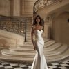 Diane by Milla Nova. Sophisticated mermaid gown in mikado with masterful drapery accentuating the hips. Featuring a heart-shaped neckline with integrated cups, a structured corset, lace-up closure at the back, and a form-fitting mermaid skirt with draping on the hips and a short train.