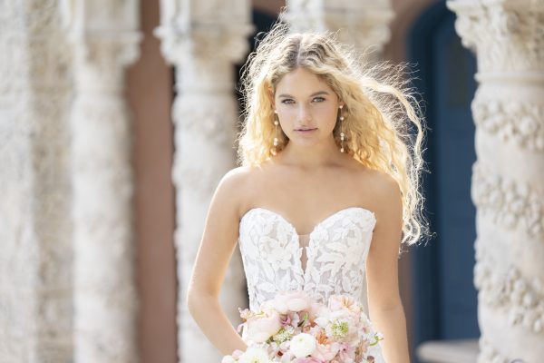 Evelyn by Allure Romance - Minimal in silhouette but rich in detail, this strapless sheath gown features a sweetheart neckline and a sheer bodice with exposed boning beneath sequin lace appliques. The soft tulle layers fall from a natural waistline into a clean, floor-length hem for an effortlessly refined finish.