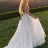 Radiant and graceful, this A-line gown features pearl, beaded, and embroidered lace appliques that glisten over layers of sparkle tulle. The V-neckline and slender straps create a flattering, open frame, while the natural waist flows into a soft, sweeping skirt. With its gentle shimmer and intricate lacework, this gown captures a beautifully romantic sensibility with just the right touch of light-catching detail.